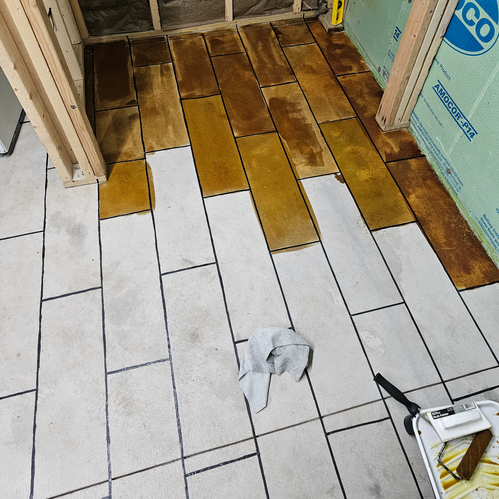 Applying Coffee Brown EverStain™ to the taped-off concrete floor