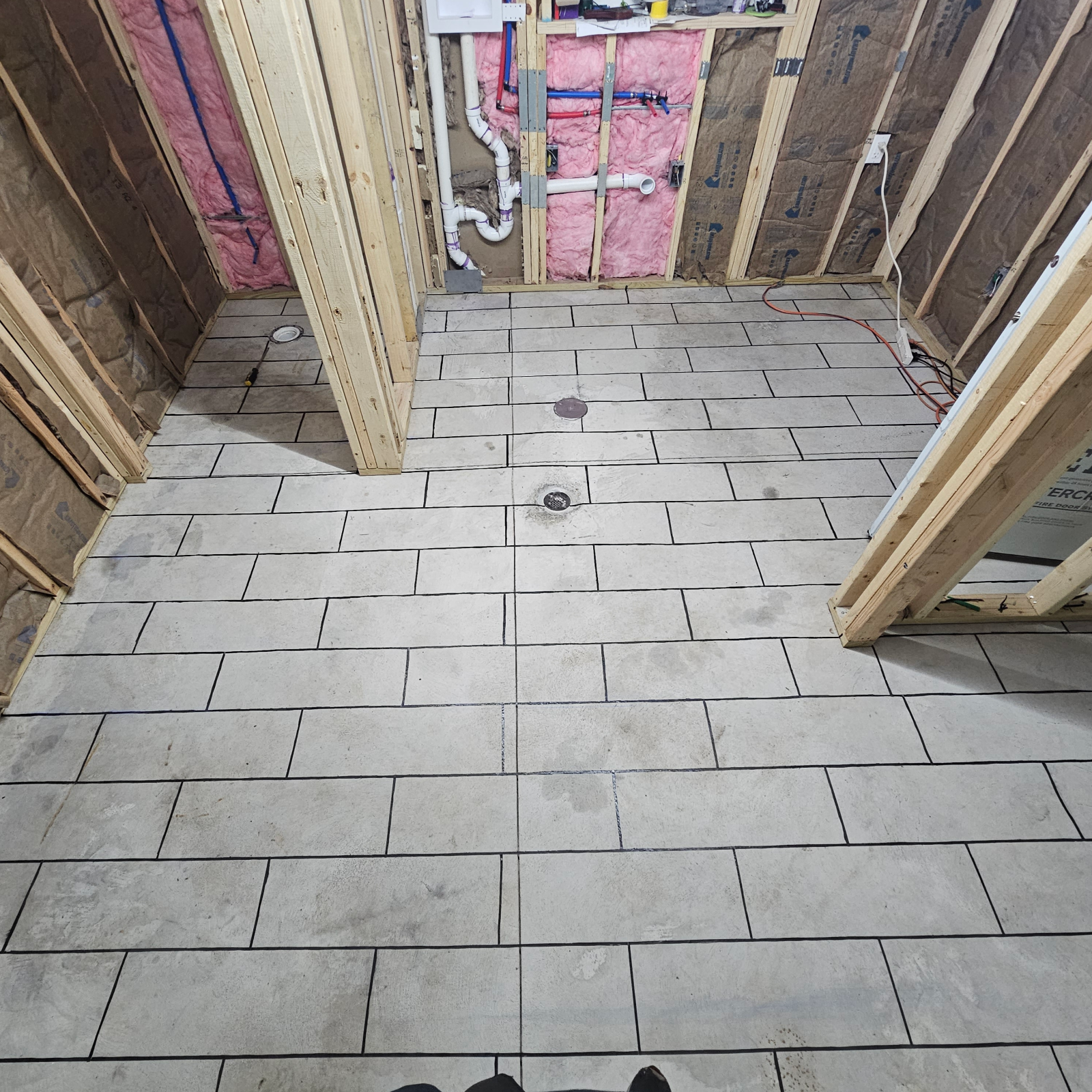 Concrete floor with duct tape neatly arranged following the chalked tile pattern