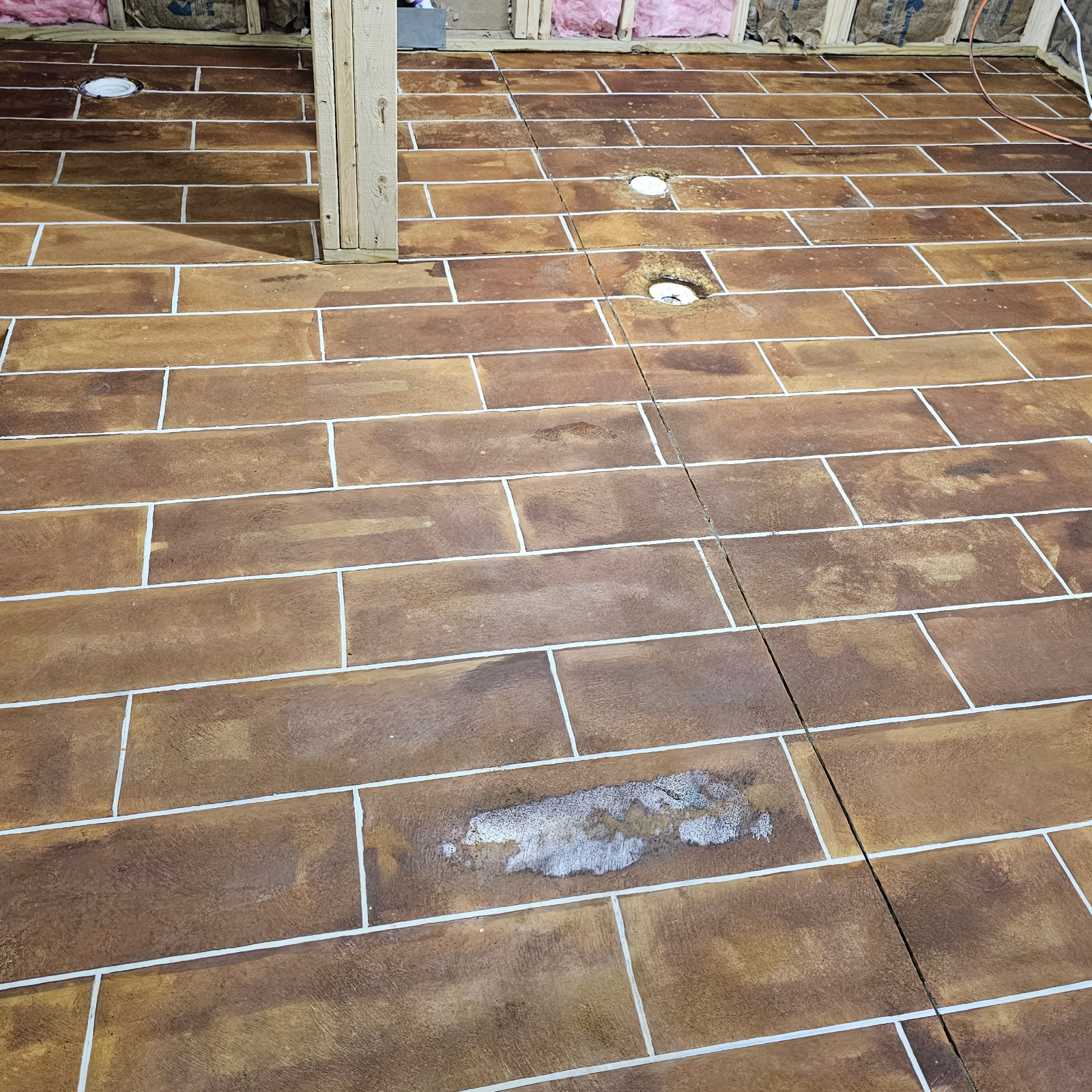 Revealing clean, crisp lines after removing the tape from the stained concrete floor