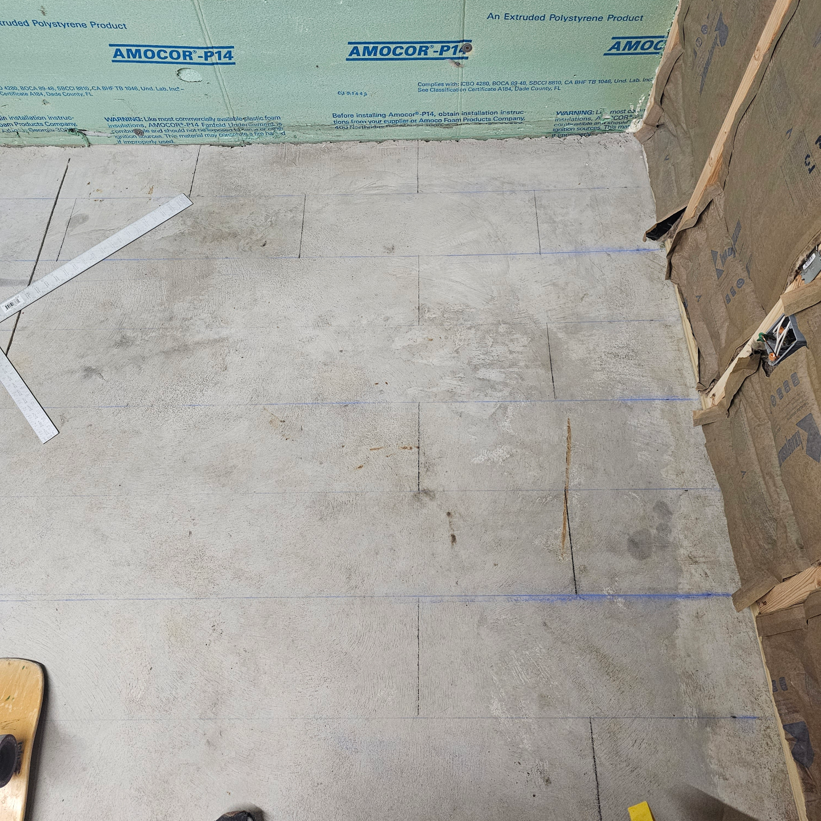 A chalk line being used to map out the future tile design on the concrete floor