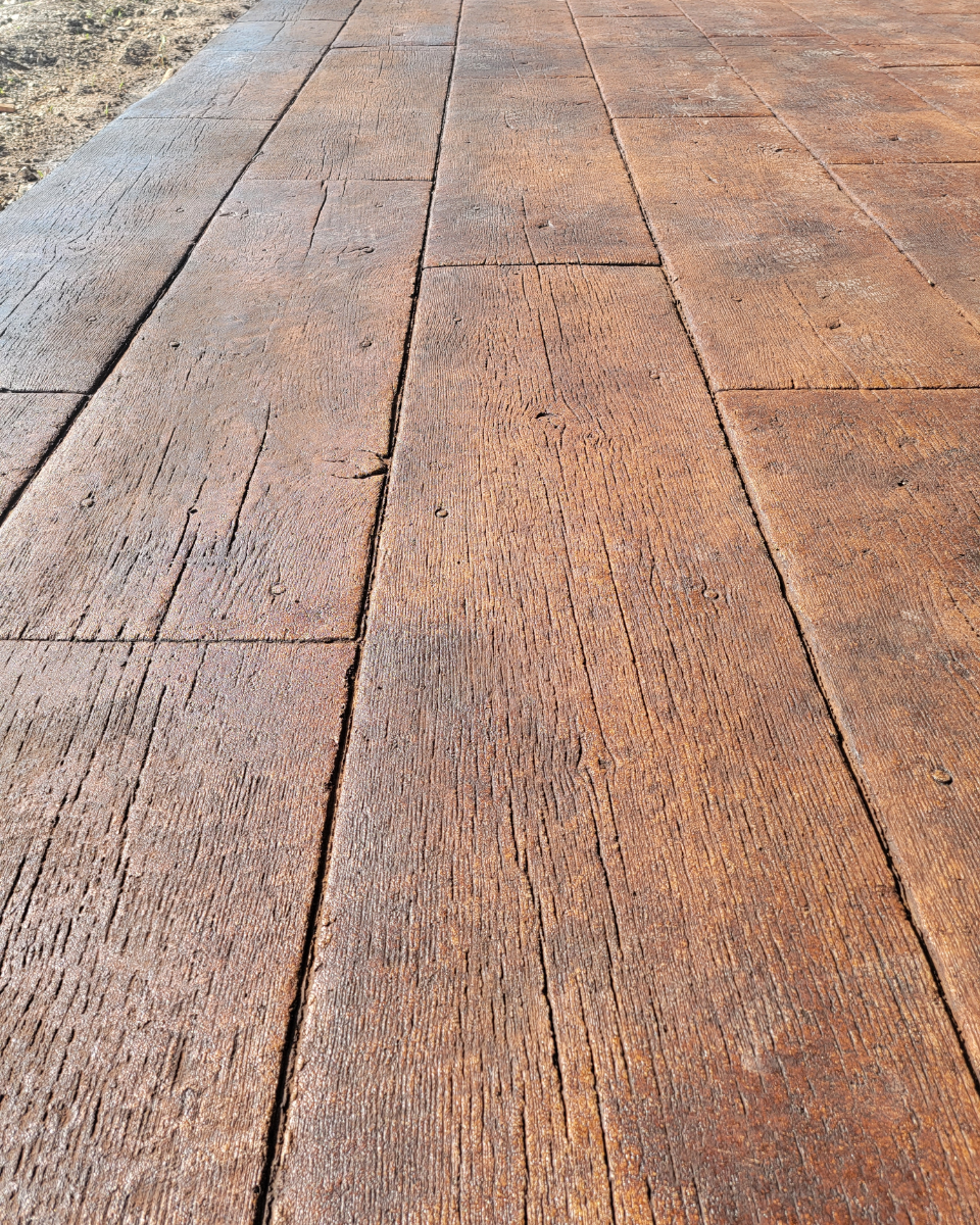 Stamped concrete patio sealed with a rich wood plank finish