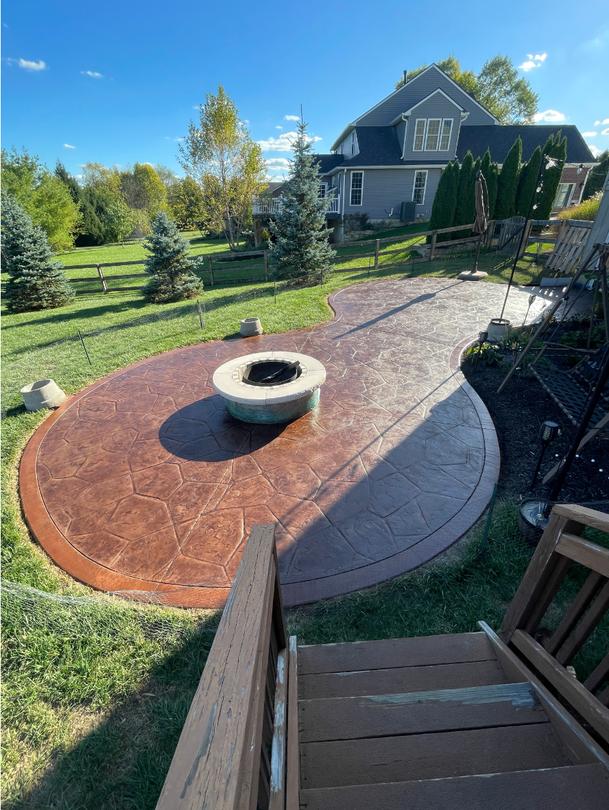 Antiquing - Patio - Aztec - Stamped - Fire Pit Stamped concrete patio with fire pit area finished in Aztec Brown and Russet border, showing rich color and glossy sealed surface.