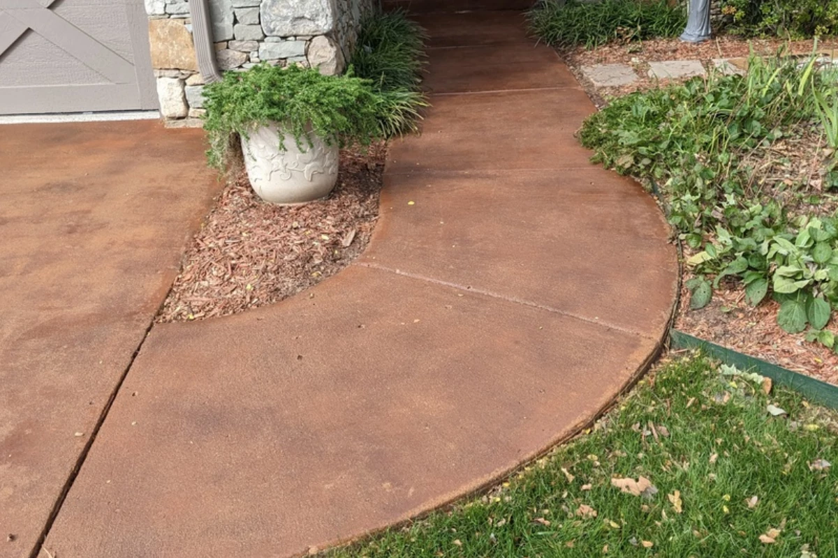 Curved front walkway finished with Portico Aztec Brown and Terracotta Curved front walkway finished with Aztec Brown stain and sealed in gloss, complementing stone exterior and landscaping.
