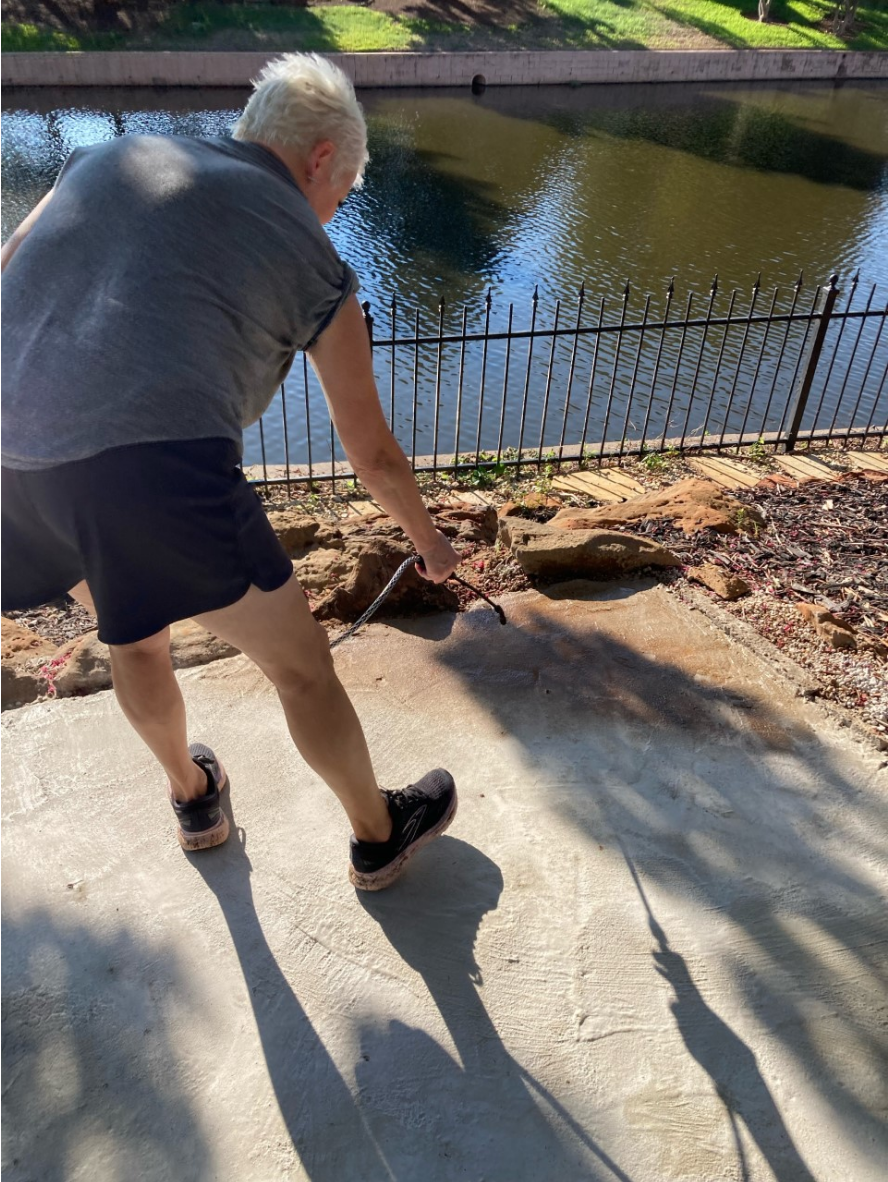 Homeowner applying Caf Royale Antiquing™ Stain to worn stamped patio using a pump sprayer Homeowner applying Café Royale Antiquing™ Stain to worn stamped patio using a pump sprayer