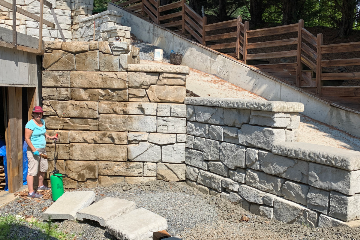 Retaining wall being finished with Caf Royale EasyTint DIYer applying Cafe Royale EasyTint Tinted Sealer to a concrete wall using a good quality sprayer