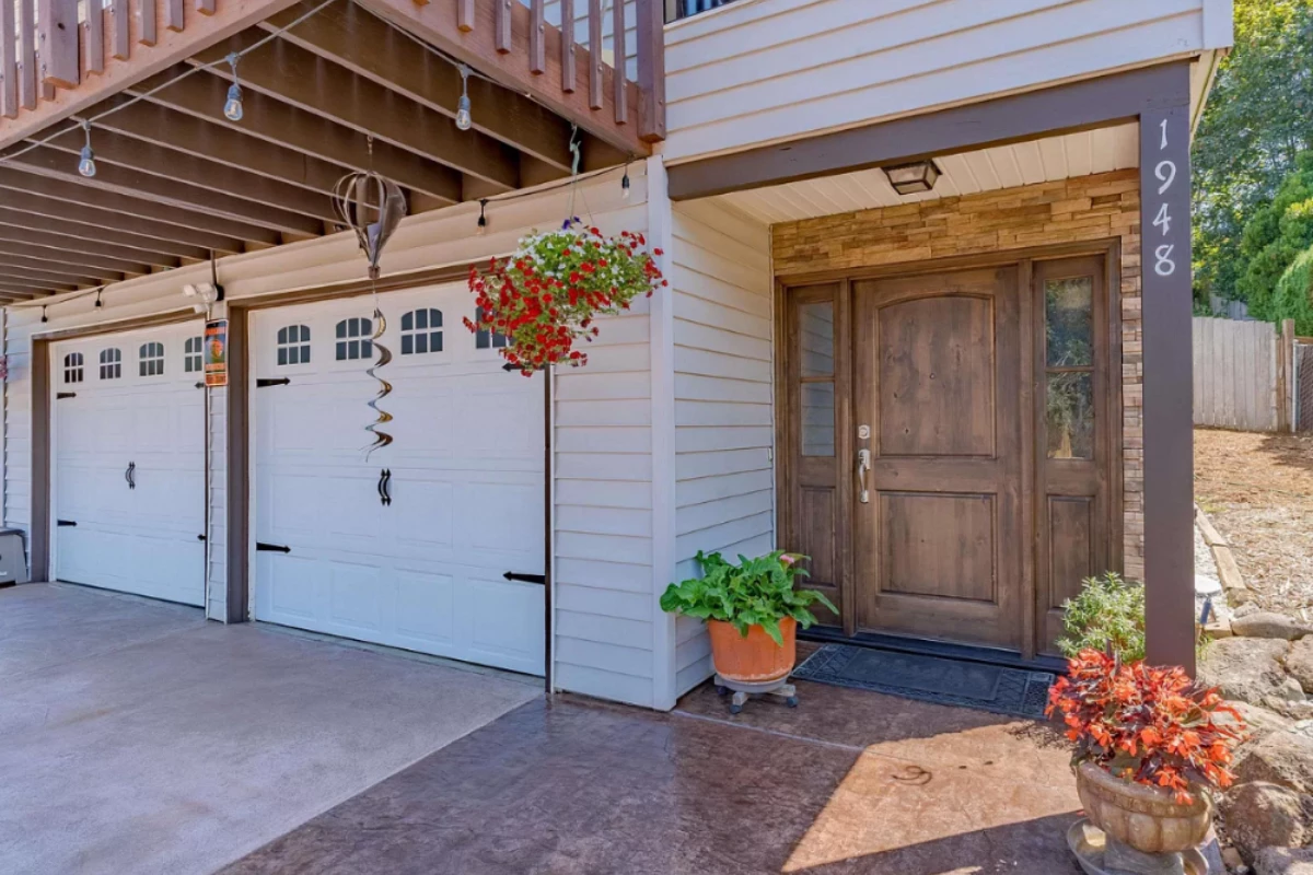 antiquing-aztec-sunset-design-broom-finish-concrete-entryway Front entryway and garage featuring two-tone stained concrete in Aztec Brown and Sunset Tan with clean detailing and vibrant curb appeal.
