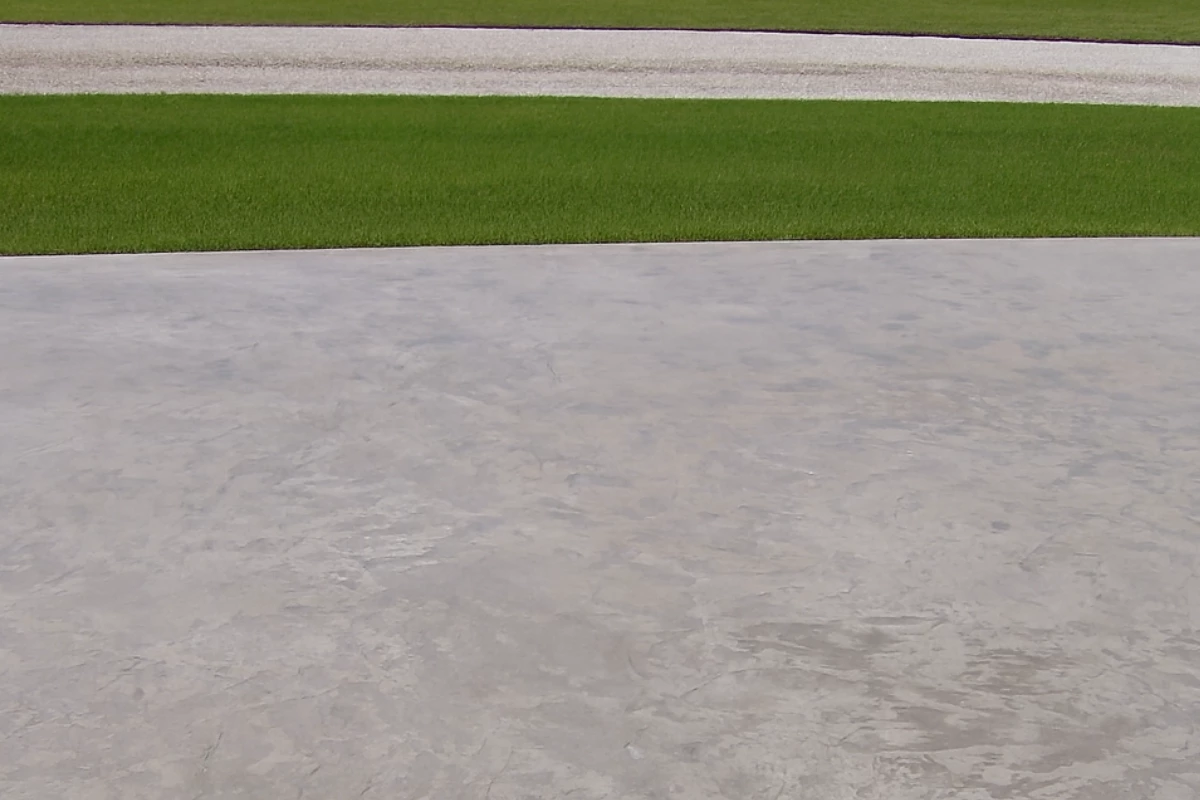 before-antiquing-stain-auburn-stamped-concrete-driveway- Faded stamped concrete driveway before color restoration with Auburn Antiquing Stain, showing light gray worn surface.