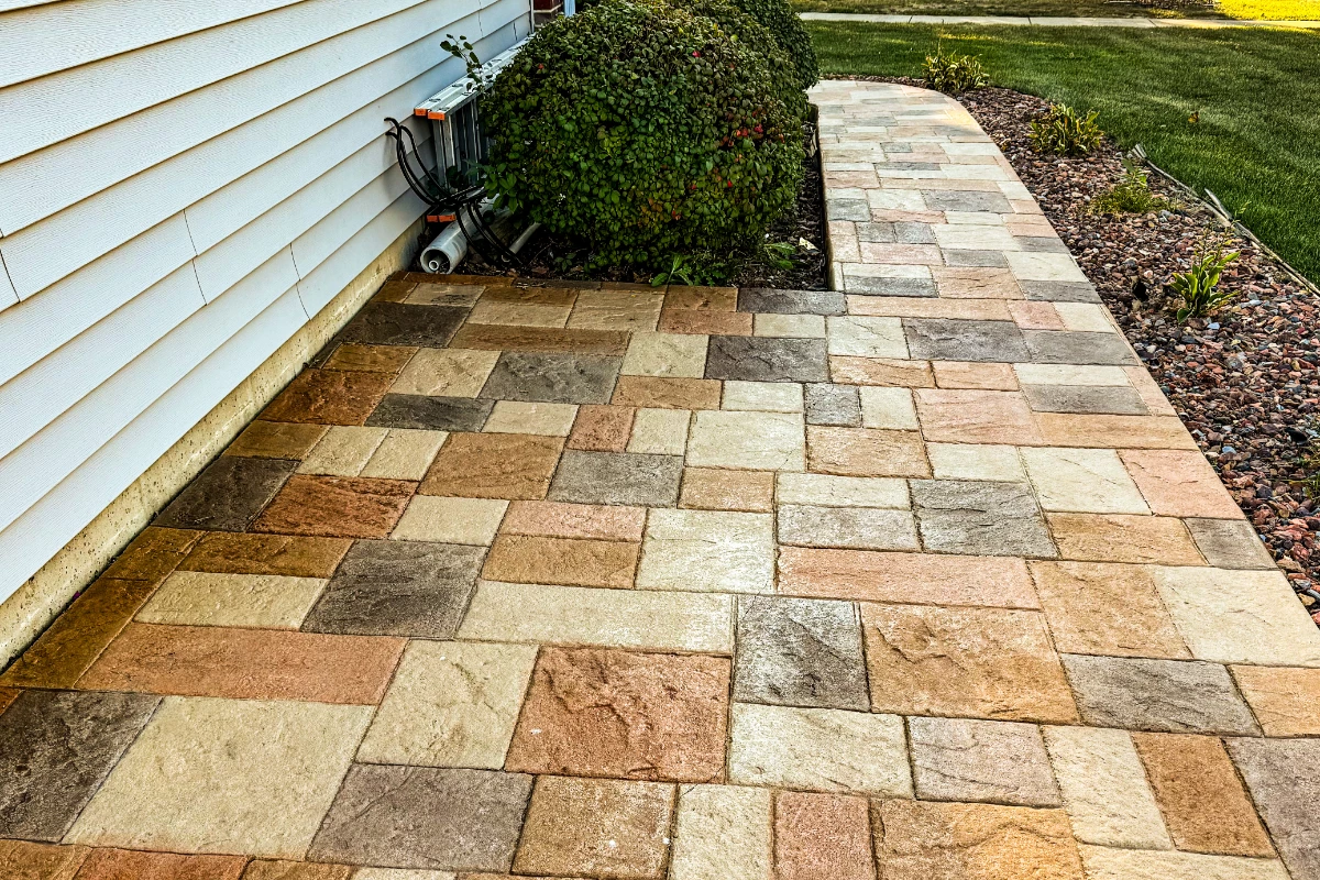 finished-antiquing-stain-auburn-khaki-terracotta-yukon-ashlar-pattern-walkway Finished Auburn, Khaki, Terracotta, and Yukon Gold-stained stamped concrete patio with outdoor furniture and glossy EasySeal finish.