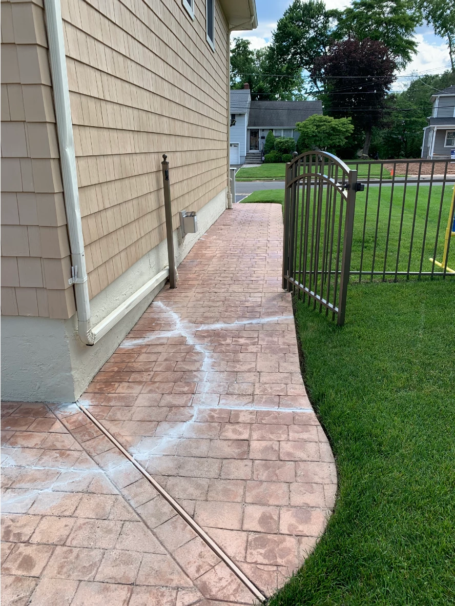 stamped concrete patio showing prominent cracks and faded coloring Before photo of stamped concrete patio showing prominent cracks and faded coloring prior to repair and staining.