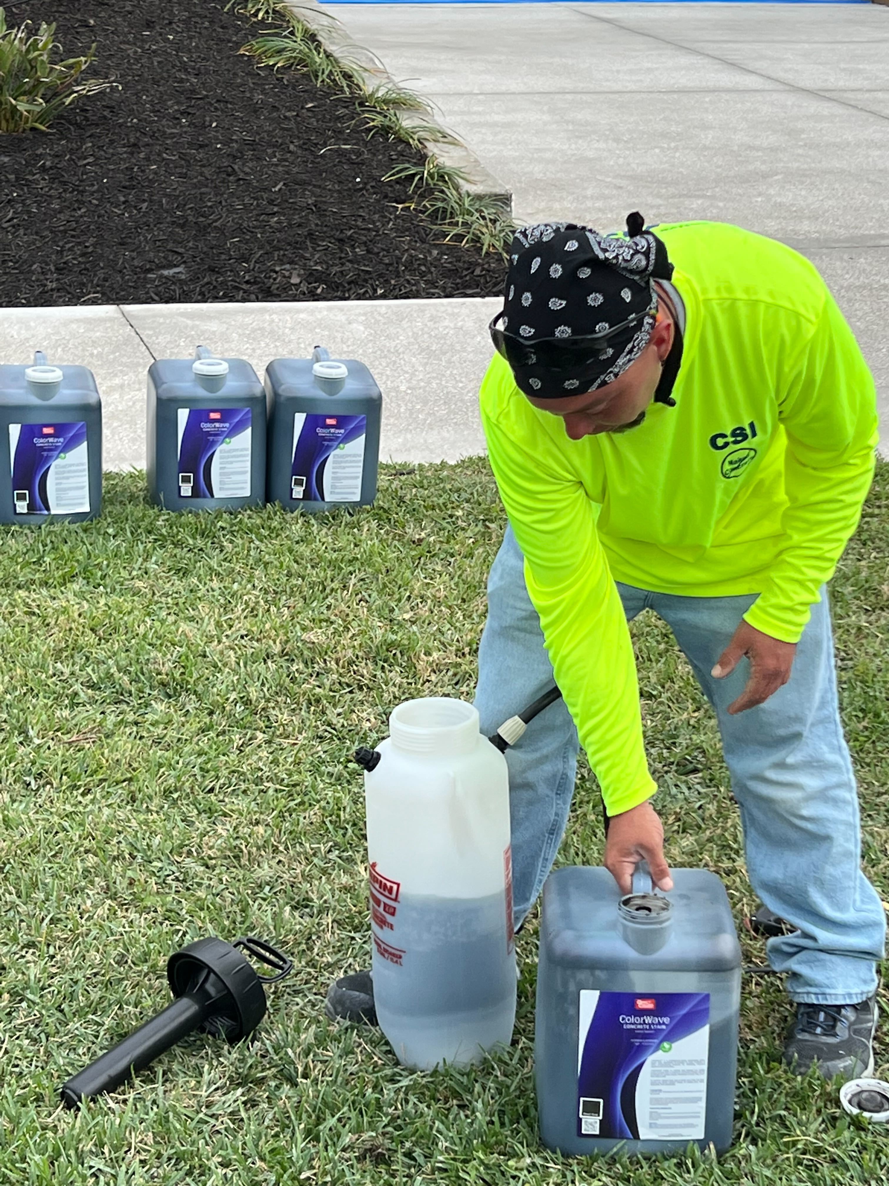 Tyler, the expert contractor, confidently preparing the ColorWave stain in the sprayer for a flawless application on the concrete driveway